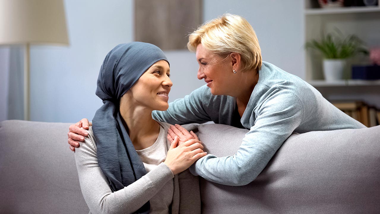 mujer con cáncer hablando con un familiar