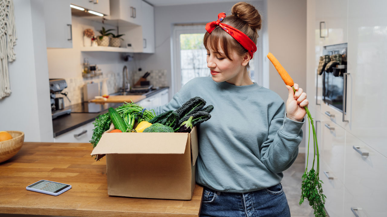 mujer con una caja de verduras