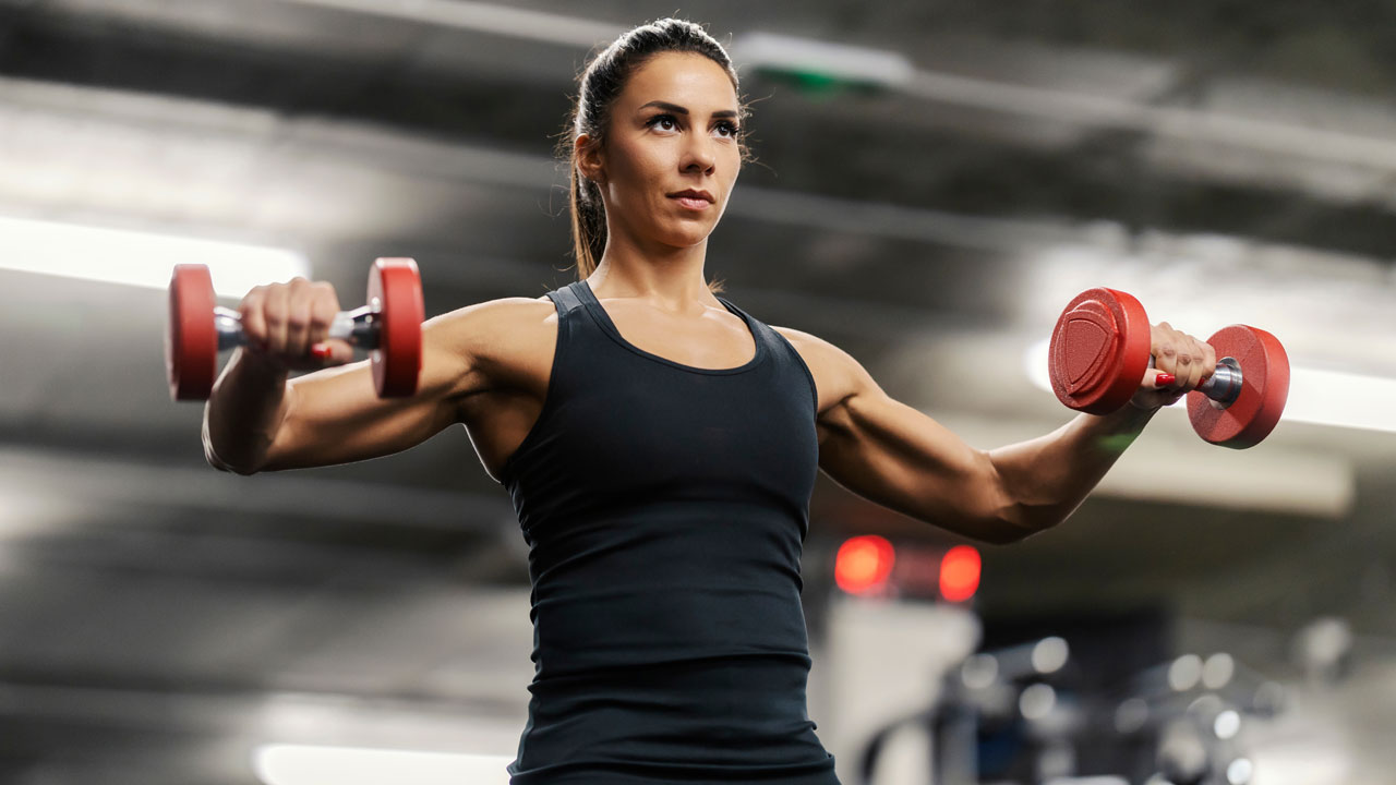 mujer haciendo pesas en el gimnasio