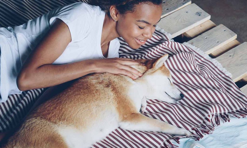 Una mujer hablando al oído de un perro