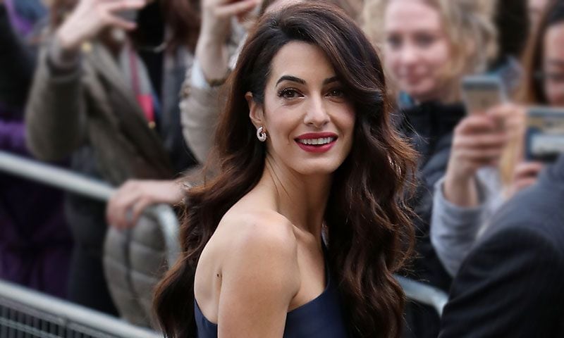 Amal Clooney encuentra en el escote asimétrico su mejor truco de estilo