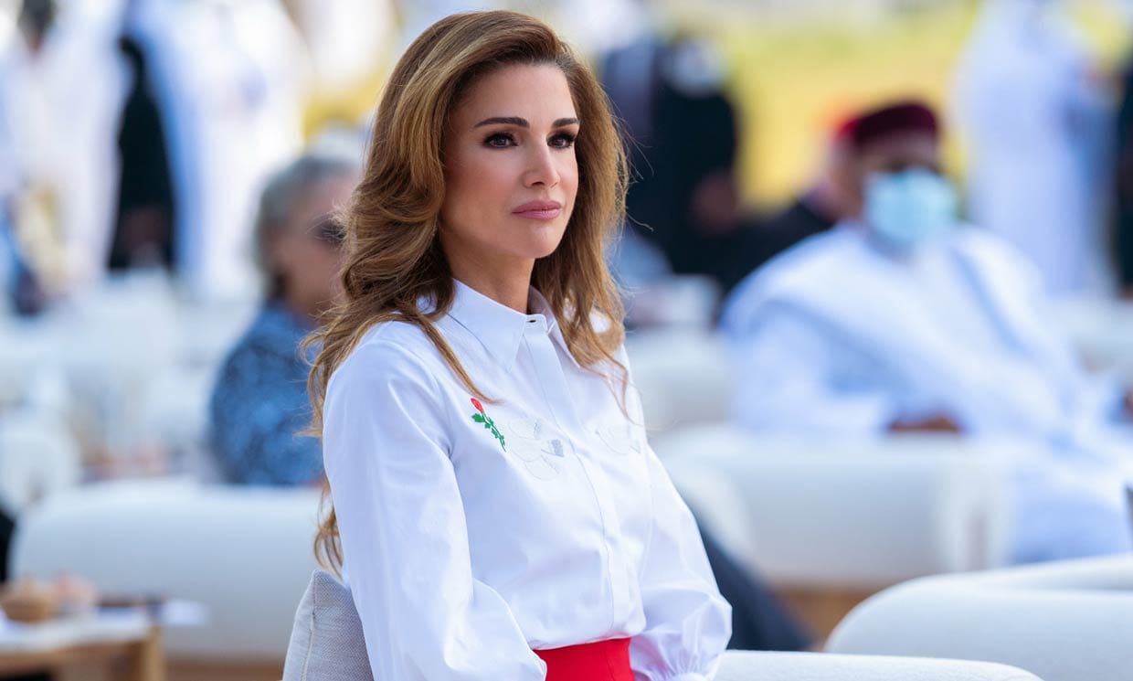 Rania de Jordania con falda roja y camisa blanca