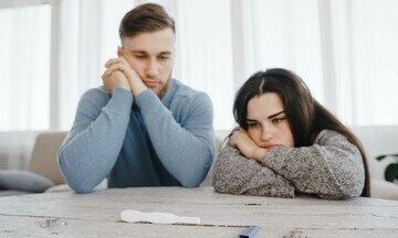 Una pareja mira desanimada el test de embarazo
