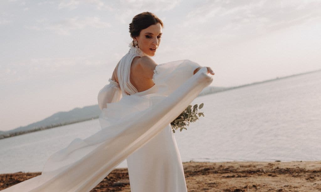 Un vestido con cuello 'halter' y manguitos para la boda al atardecer de Laura en la playa