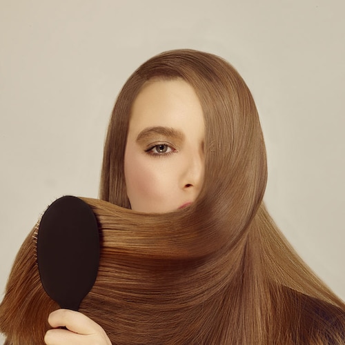 Mujer cepillando el pelo liso