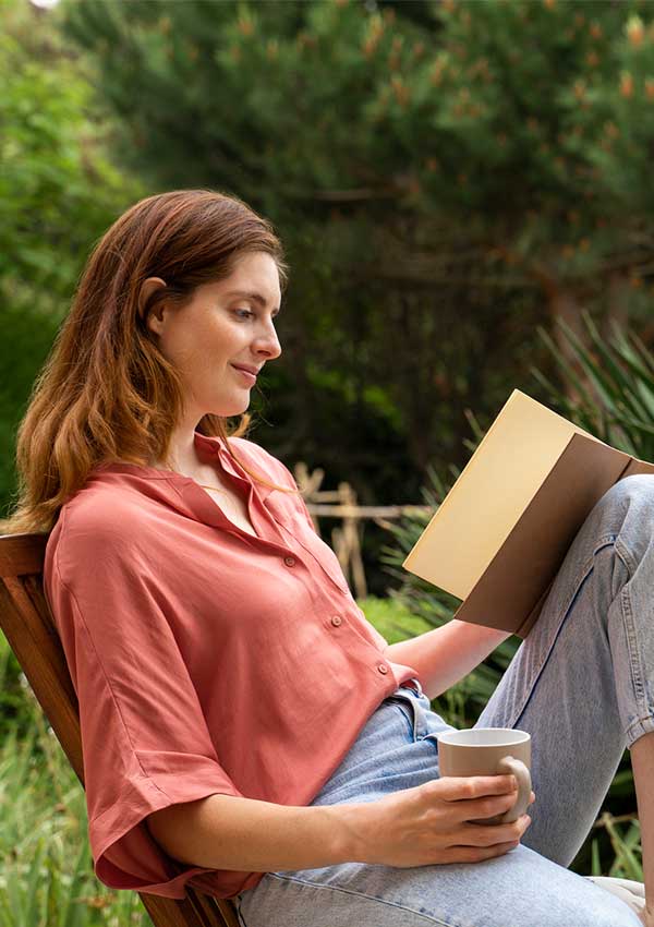 Mujer leyendo libro en el jardin
