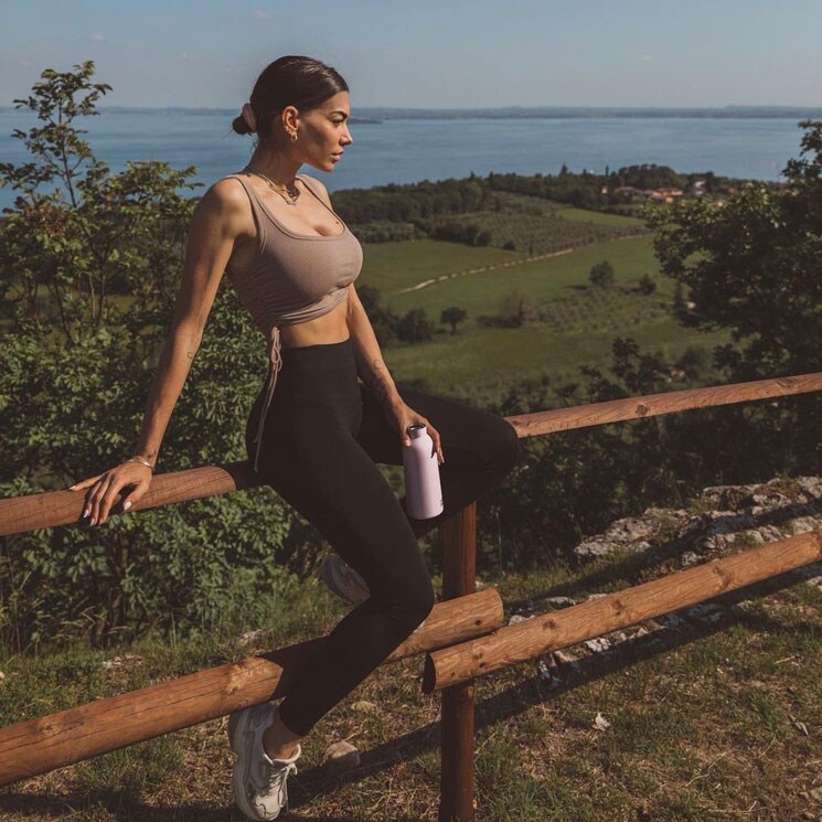 Chiara Sbardellati con conjunto deportivo y botella de agua en el monte