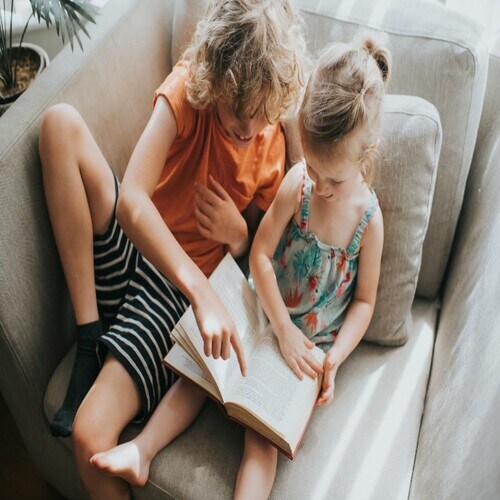 Dos niños leyendo un libro