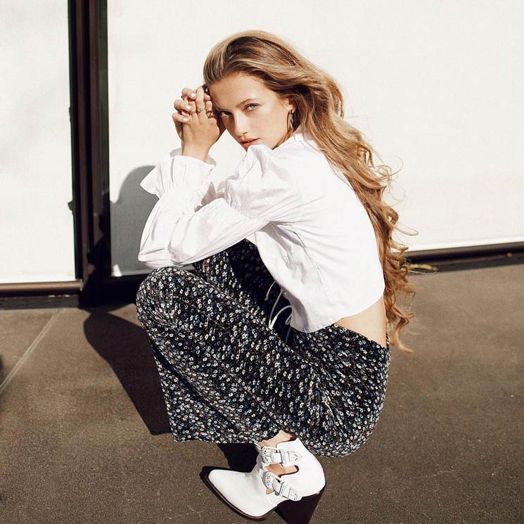 Zoë Pastelle con camisa blanca, pantalón estampado y botines