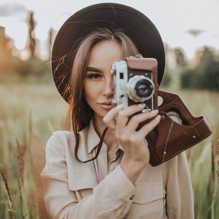 Una chica haciendo una fotografía con una de las mejores cámaras para principiantes