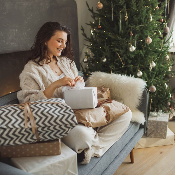Mujer abriendo regalos de Navidad
