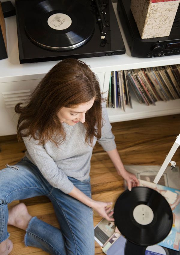 Mujer escuchando música con disco de vinilo