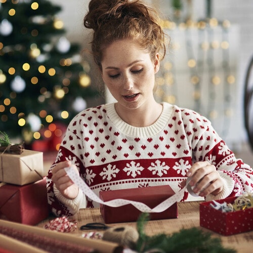 Mujer envolviendo regalos de Navidad