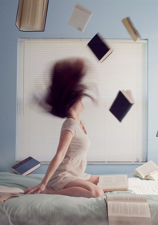 Una chica rodeada de libros en su habitación