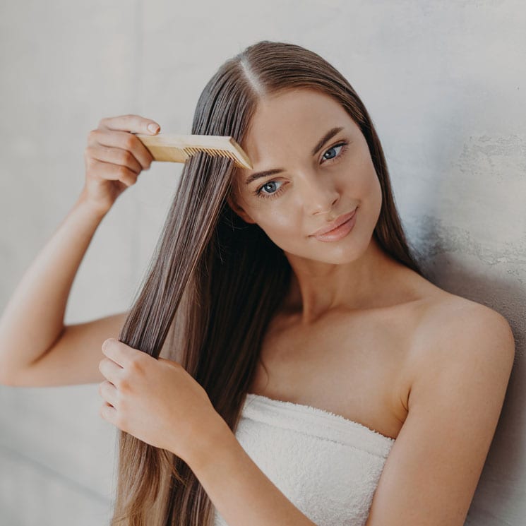 Mujer peinándose el pelo húmedo