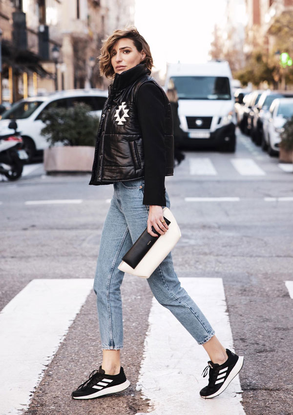 Eugenia Osborne con vaqueros, chaleco acolchado y zapatillas negras de Adidas