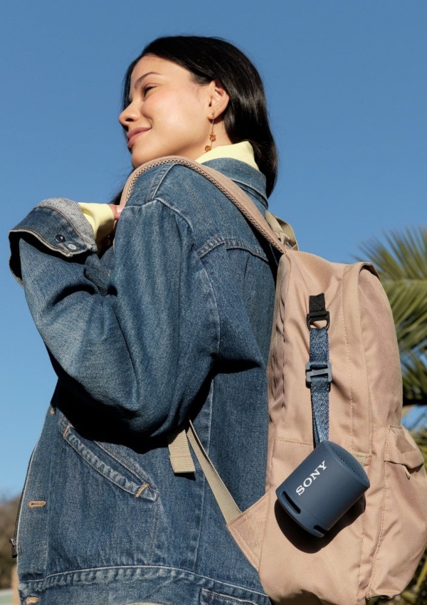 Modelo llevando en su mochila un mini altavoz de la marca Sony