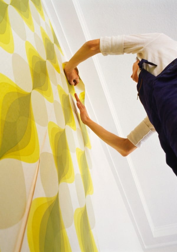 Persona colocando un papel pintado en la pared