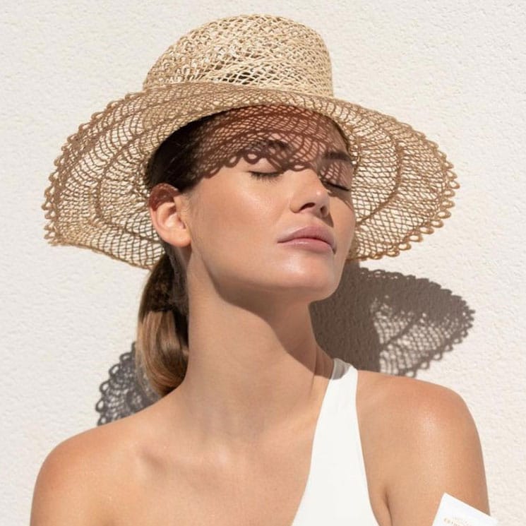 Mujer tomando el sol con sombrero 