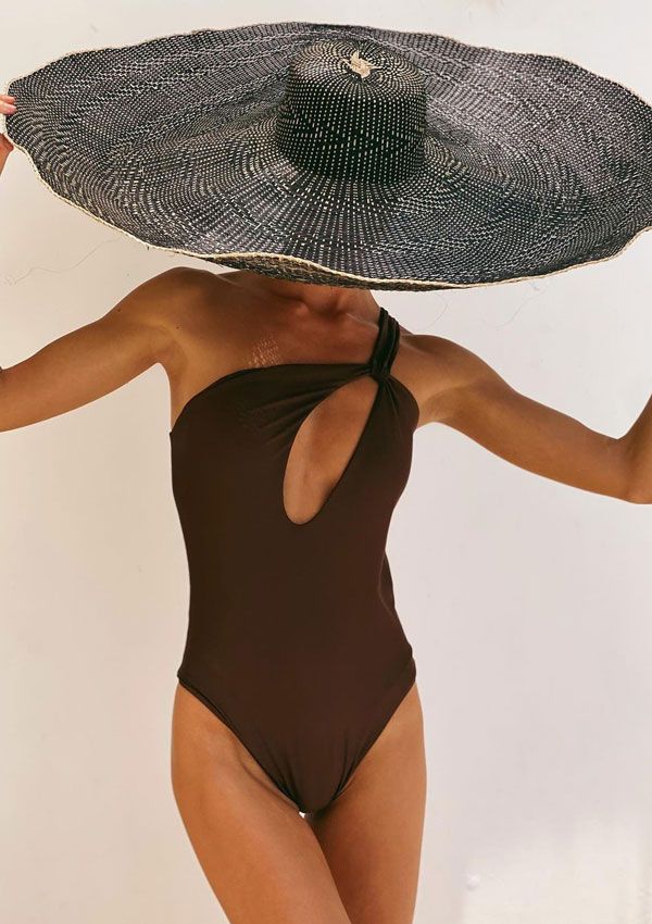 Mujer con bañador asimétrico y sombrero de ala muy ancha