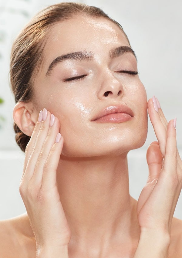 Mujer limpiando su rostro con productos de Charlotte Tilbury
