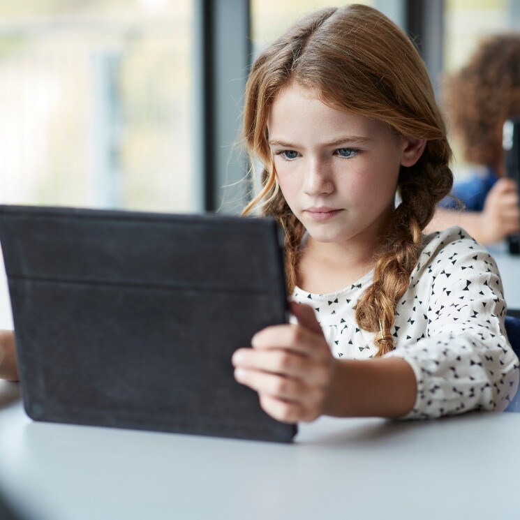 Niña estudiando en casa con tableta