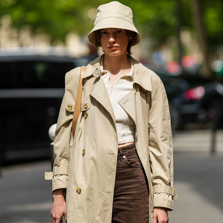 Mujer con pantalones de pana marrones, top de punto y gabardina