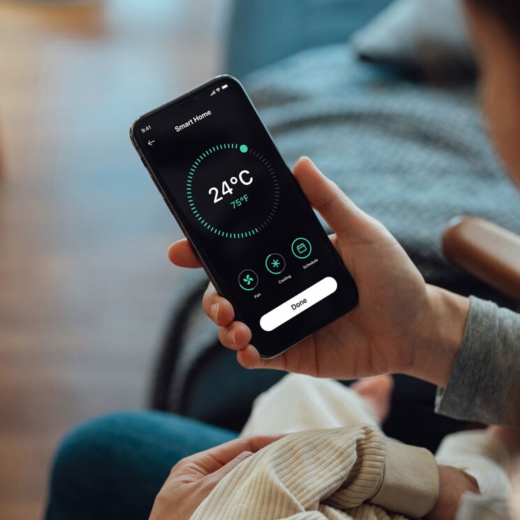 Mujer con aplicación de termostato inteligente en su teléfono móvil