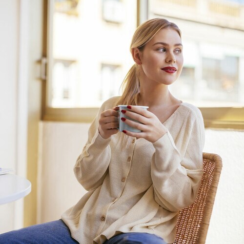 Mujer tomando café en su casa