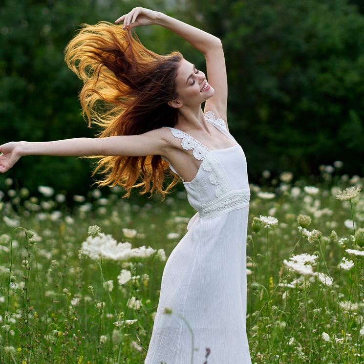 Mujer con vestido blanco y cabello suelto en el campo