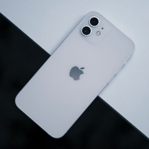 Un iPhone 13 en una mesa blanca y negra