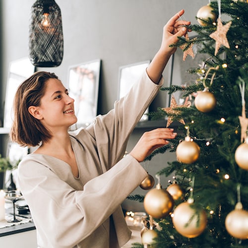 Mujer decorando el árbol de Navidad