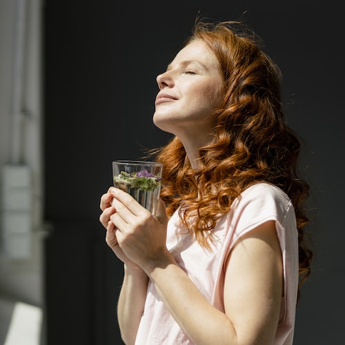 Mujer tomando un vaso con hierbas
