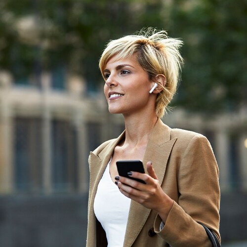 Una chica usando un móvil y auriculares