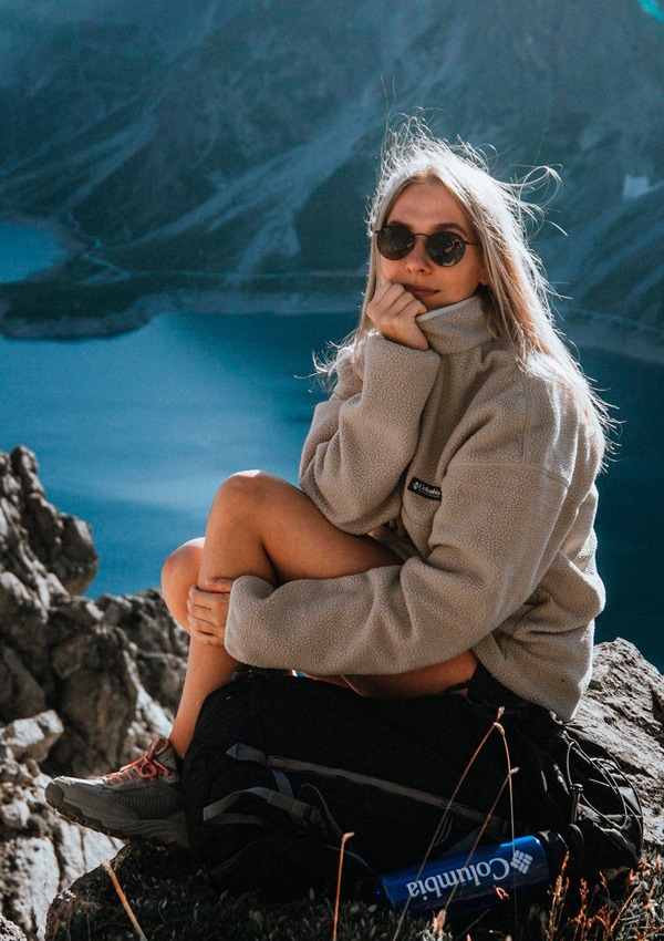 Mujer en la montaña con chaqueta polar y botas de Columbia
