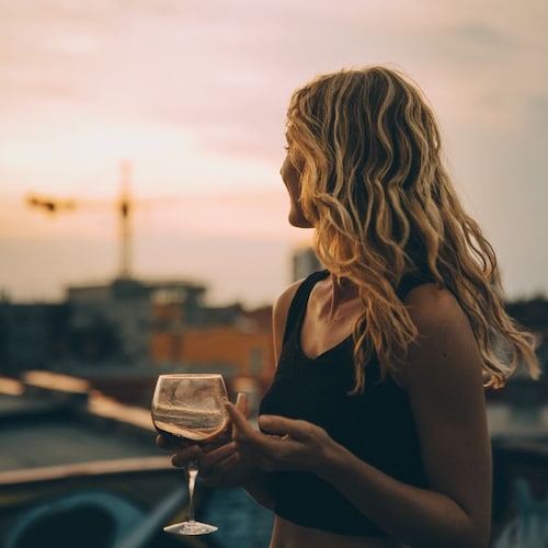 Mujer bebiendo vino en la ciudad