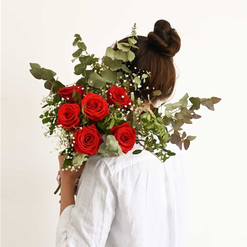 Mujer con ramo de rosas rojas
