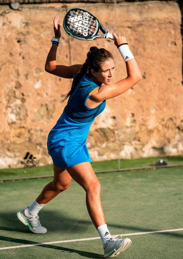 Marta Ortega jugando al pádel en pista exterior con zapatillas y pala de Adidas