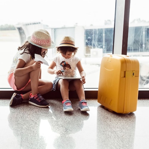 Niños viajando con su maleta en un aeropuerto