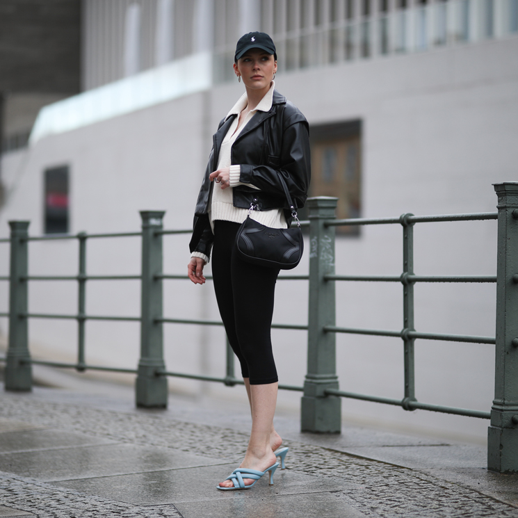 Mujer con pantalones capri negros, polo blanco, biker y zapatos de tacón destalonados