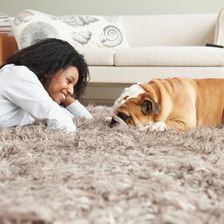 Mujer con su perro en la alfombra
