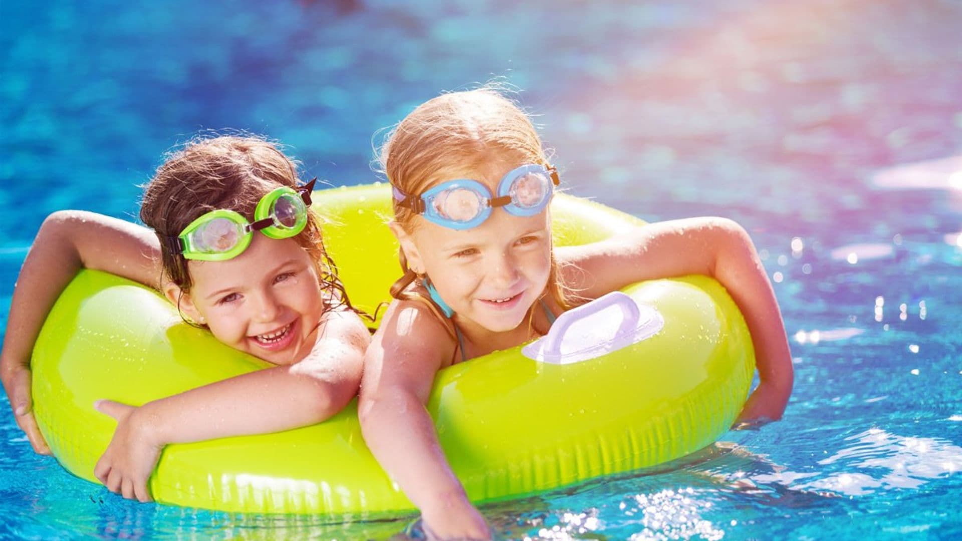 Niños bañándose con un flotador en la piscina