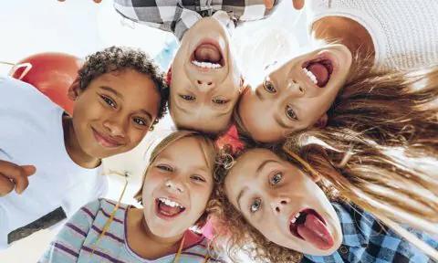 Niños reunidos sacando la lengua