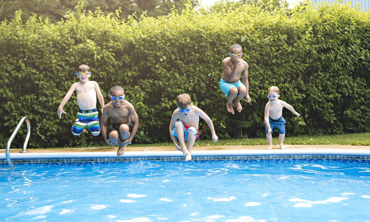 Niños jugando en la piscina en verano.
