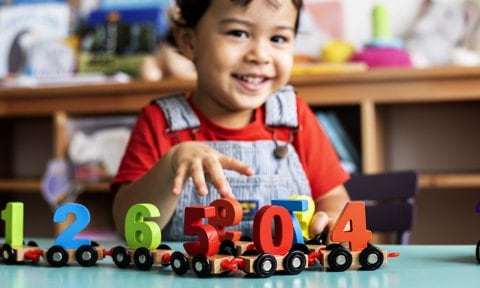 Niño jugando con un tren de números.