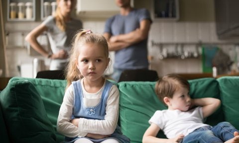 Niño y niña enfadados o frustrados en el sofá de su casa.