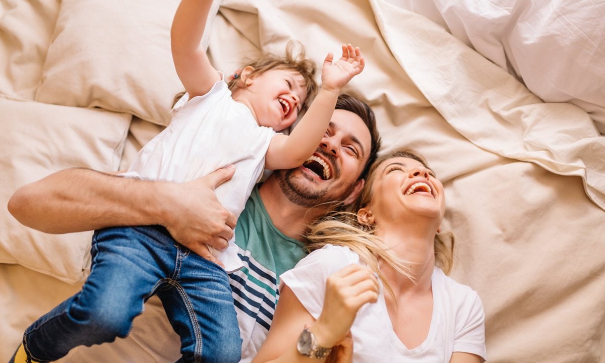 Familia feliz riendo en la cama