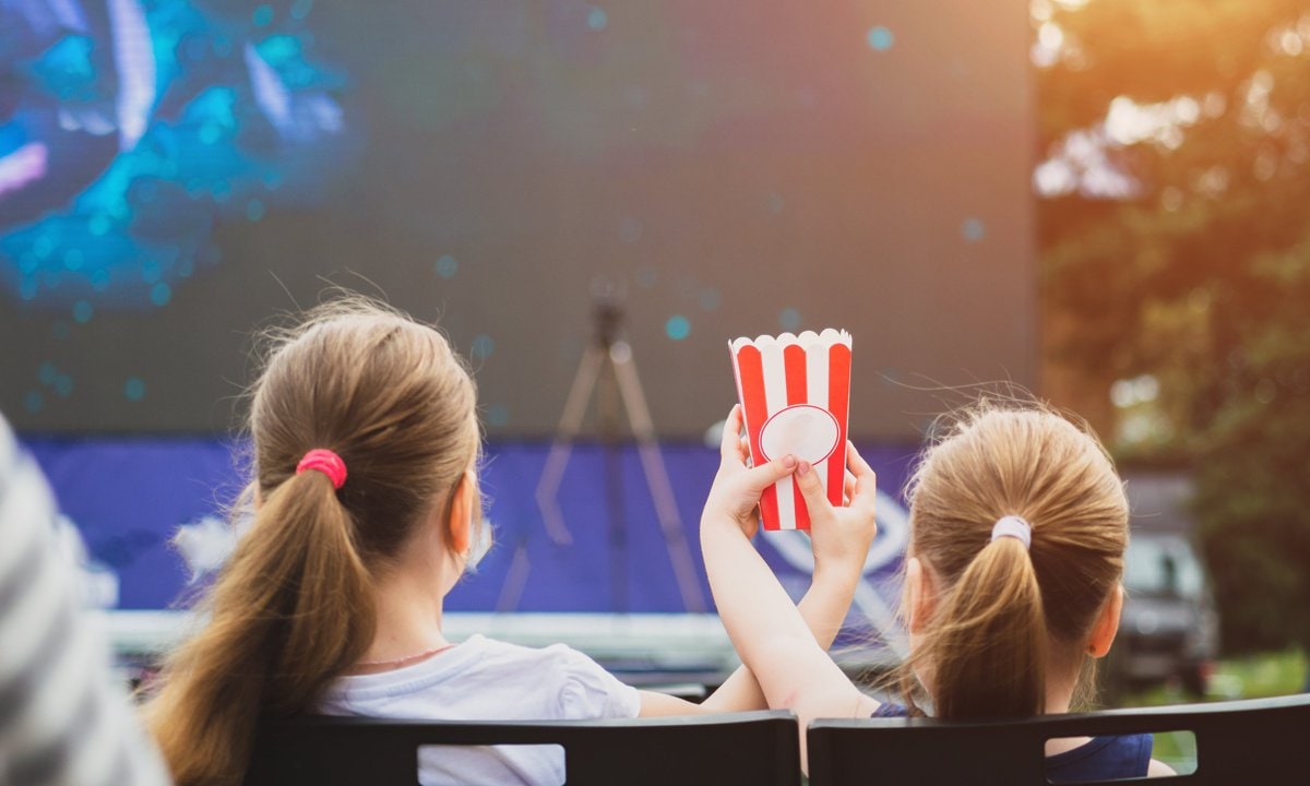 Películas infantiles para ver en verano. Niños en cine de verano con palomitas.