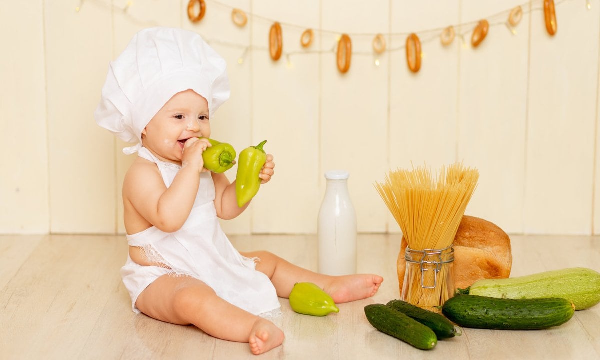 Bebé disfrazado de chef con distintos alimentos