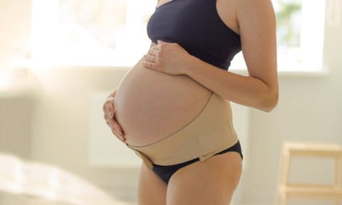 Mujer embarazada con un cinturón pélvico